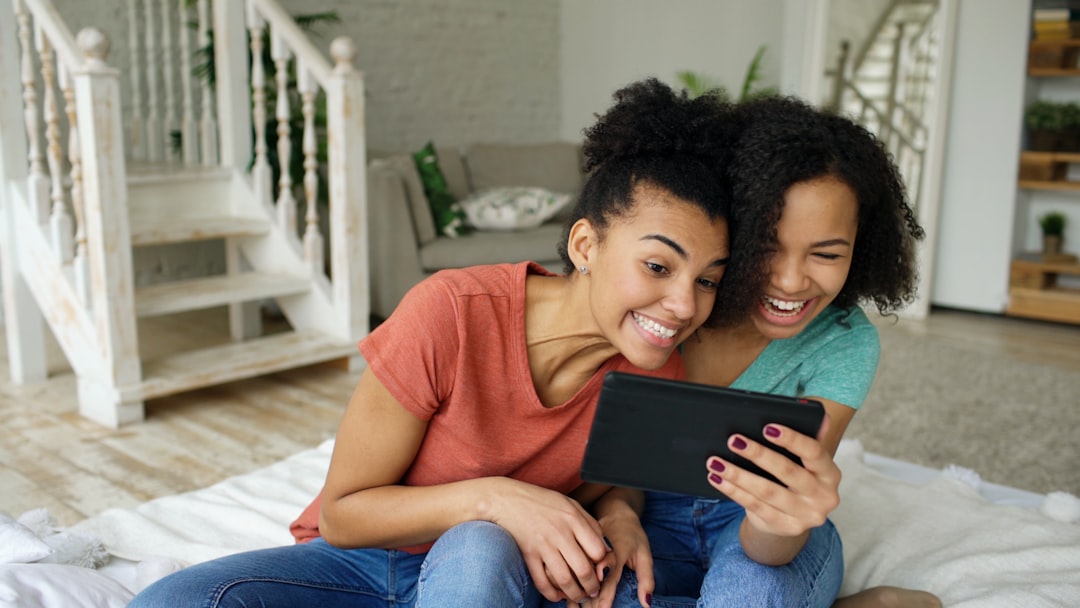 A happy couple relaxing on a sofa while browsing real estate listings on a tablet, representing buyers instantly finding a Slidell home online.