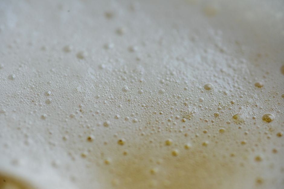 A detailed close-up shot of freshly applied spray foam insulation, highlighting its expansive and textured surface for a modern, clean look.